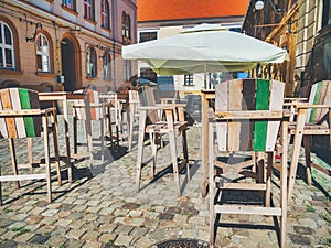 Wooden chairs and table on a cobbled street. Outdoor restaurant terrace cafe in the center of Timisoara city, Romania