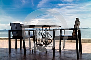 Wooden chairs and table on sea terrace restaurant against sunlight photo