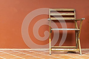 Wooden chairs on terracotta floors and orange plaster walls background, wooden chairs on the balcony