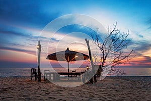 Wooden chairs and umbrellas on sand beach