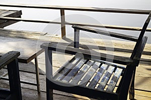 Wooden chairs on wood pier overlooking lake