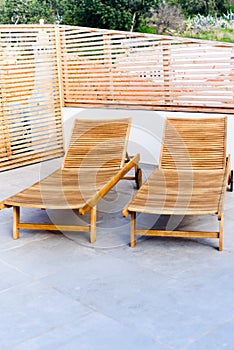 Wooden chaise lounges sunbed with wheels in patio