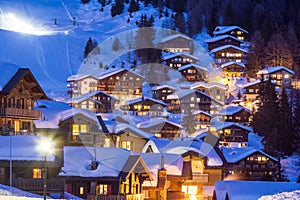 Wooden chalets covered with deep snow at the blue hours