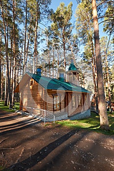 Wooden chapel in pine forest in Chemal