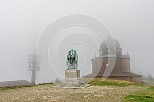 Wooden chapel statue and ,radio and televison transmitter on summer foggy day in Beskid mountains in Czech Republic photo