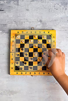 Wooden chess board and woman`s hand making chess move