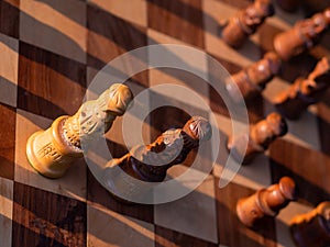 Wooden chess board with wooden pieces with sunlight