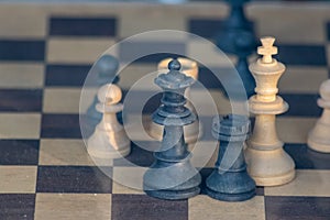 Wooden chess figures on antique chess table show the competitive chess game with strategic and intelligent battles to checkmate