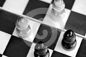 Wooden chess figures on a chessboard. Top view black and white