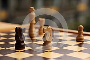 Wooden chess pieces on a cage board, skyline intentionally curved close-up, copy space