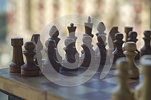 Wooden chess pieces on the chessboard with blurred background