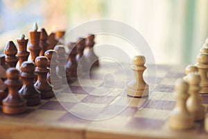 Wooden chess pieces on the chessboard with blurred color background