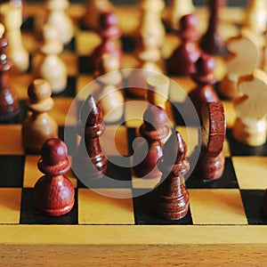 Wooden chess pieces on a chessboard, king in focus