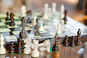 Wooden chess pieces on chessboard outdoor at the sunny day, at terrace house.