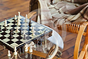 Wooden chess pieces on chessboard outdoor at the sunny day, at terrace house.