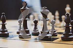 Wooden chess pieces on the table closeup