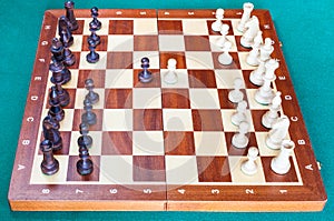 Wooden chessboard with first chess pawn moves