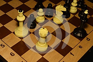 Wooden chessboard and white chessmen as a sport backdrop