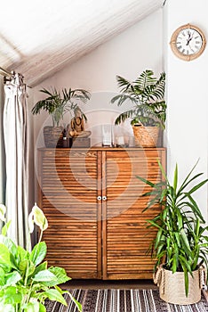 wooden chest of drawers with decorations and flowers in the interior