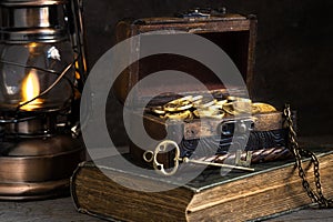 Wooden chest with gold coins and treasure key, concept of wealth, pirate treasure