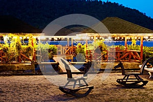 Wooden children`s rocking chairs on the beach