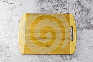 Wooden chopping board on concrete table and brick wall