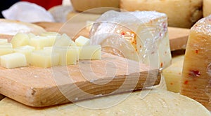 wooden chopping board wtih pieces of cheese