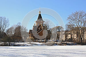 Wooden Christian church in small town near lake.