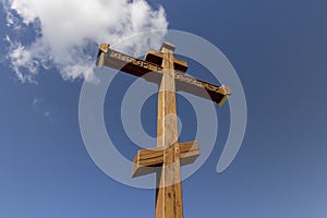 wooden christian cross on a blue sky background