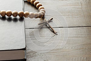 Wooden Christian Cross next the Closed Bible