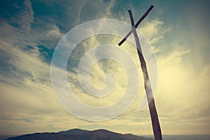 Wooden christian cross under a cloudy sky