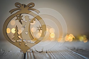 Wooden Christmas angel ornament against a blurred background of fairy lights