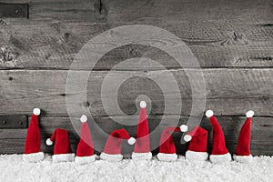 Wooden christmas background with red santa hats for a festive fr