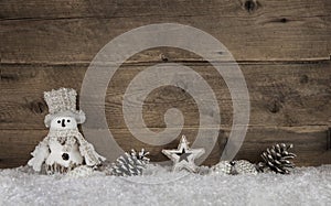 Wooden christmas background with a snowman and natural decoration.
