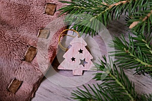 Wooden Christmas tree toy, warm fluffy plaid and branche of Christmas tree. Christmas still life. Rustic style. Noise effect