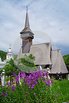 The wooden church from Botiza. `All Saints` Sunday` church in the background. Maramures County.