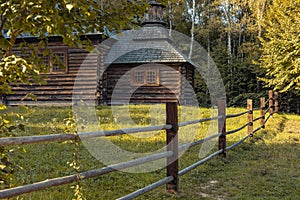 Wooden church landmark building in wood land outdoor environment space with rural fence and yellow foliage in fall season