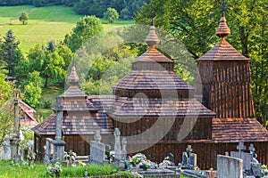 Wooden church of Saint Michael the Archangel in Prikra during summer with the cemetery