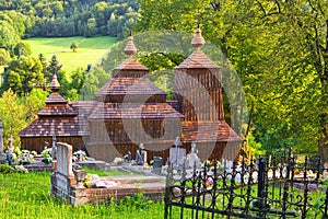 Wooden church of Saint Michael the Archangel in Prikra during summer with the cemetery
