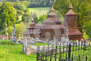 Wooden church of Saint Michael the Archangel in Prikra during summer with the cemetery