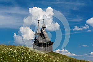 Wooden church on the top of the hill. Vershinino village sunset view. Arkhangelsk region, Northern Russia.