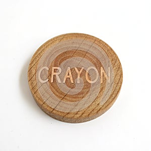 Wooden circle with \'crayon\' text isolated on white background photo
