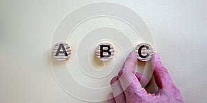 Wooden circles with letters a, b, c and hand holding one of circles. Conceptual image of business planning and different options