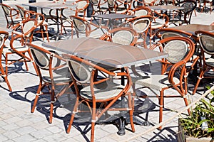 Wooden classic french chairs on cafe outdoor restaurant coffee and metal tables parisian terrace