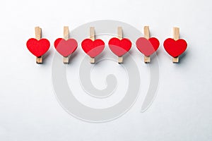 Wooden clips with red heart. White background with copy space