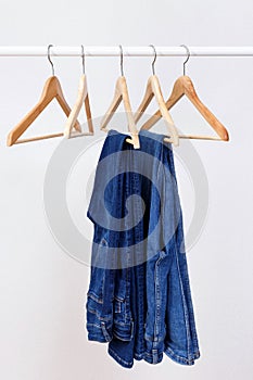 Wooden clothes hangers with blue jeans. Jeans background. Blue jeans.