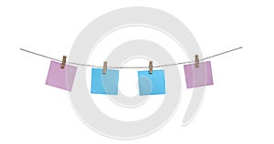 Wooden clothes pins with blank blue and pink paper hanging on brown rope isolated on white background