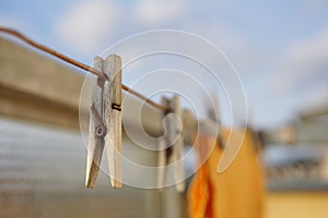 Wooden clothespin peg hanging on the balcony string as a symbol of washing clothes at home