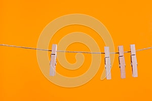 Wooden clothespins hanging on a clothesline rope