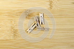 wooden clothespins on light yellow bamboo background